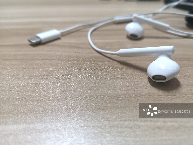 Type-C接口白色有绳耳机，木桌背景图片素材