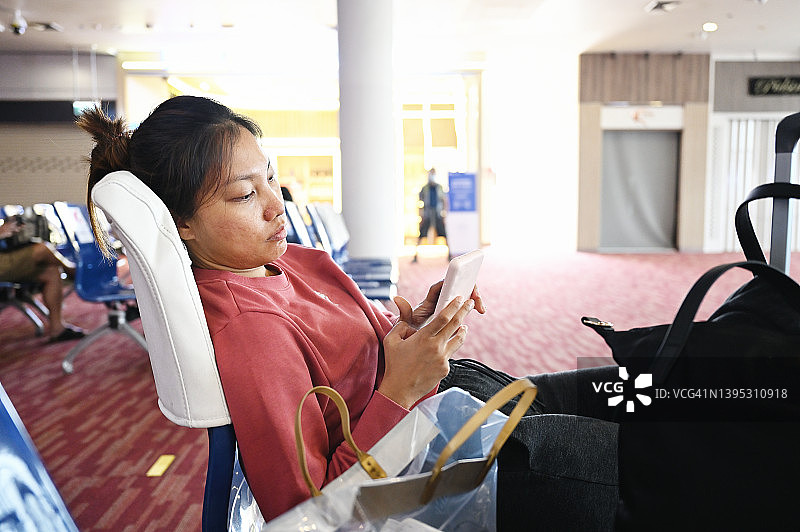 在机场使用手机的女人图片素材