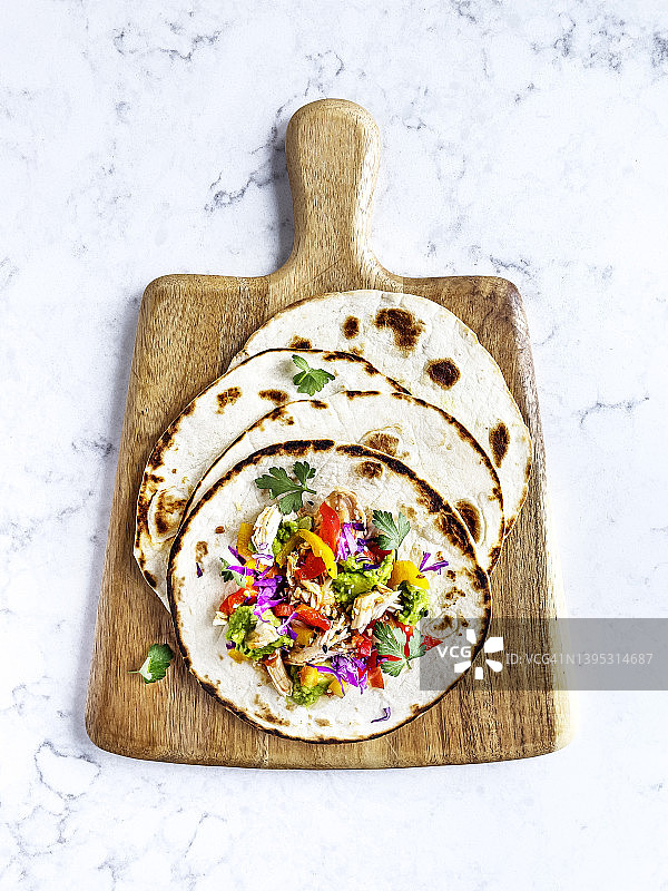 白色背景木制砧板上的鸡肉玉米卷图片素材