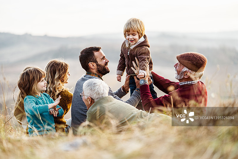 快乐的多代同堂家庭在秋日野餐时玩耍图片素材