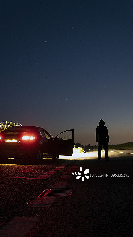 夜晚停在路边的神秘兜帽人（竖版）图片素材