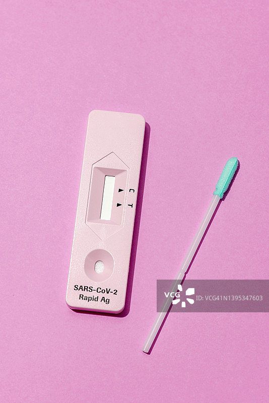 品红色背景上的新冠病毒快速抗原检测图片素材