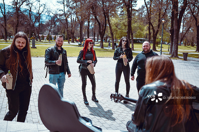 现代街头艺人在公园为朋友表演音乐会图片素材