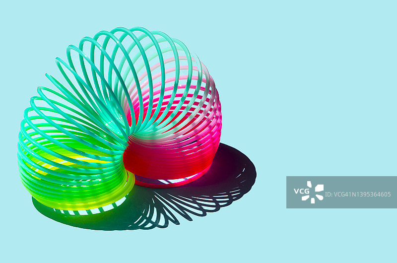 蓝色背景上的彩色弹簧玩具图片素材