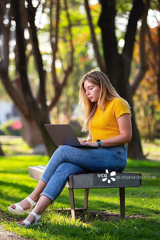 年轻女人在公园工作图片素材