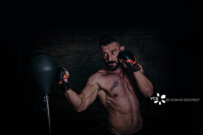 专注的年轻男人在健身房进行拳击训练图片素材