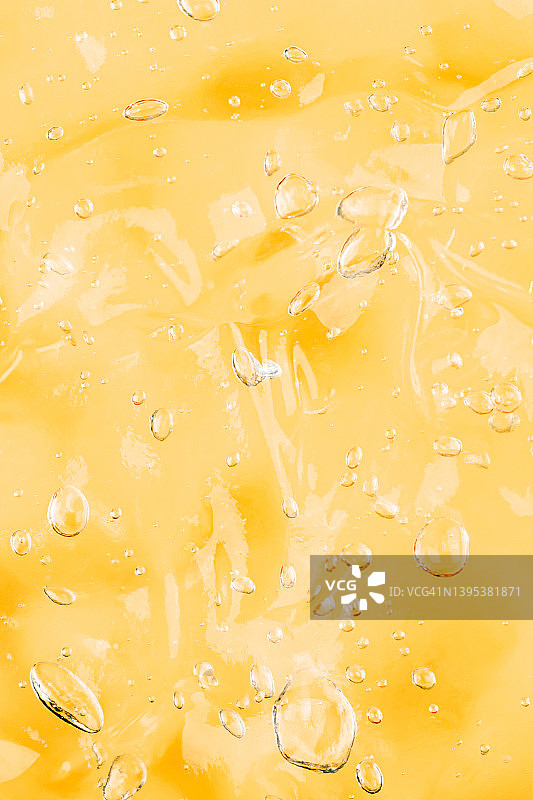 透明黄色涂抹质地，维生素C面部精华，带气泡的抗菌凝胶，护肤化妆品，竖向图案图片素材