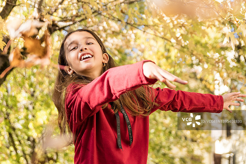 玩弄秋天落叶的小女孩图片素材
