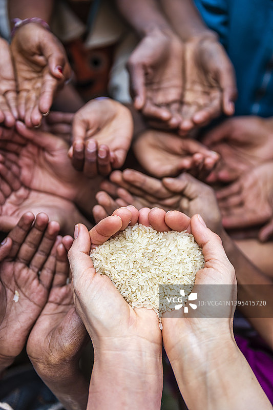 志愿者白人妇女向饥饿的儿童捐赠大米图片素材