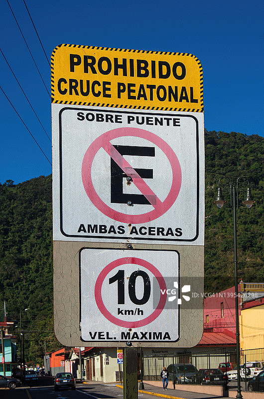 西班牙语道路警告标志，上面写着：“Prohibido cruce peatonal。Sobre puente no estacionamiento ambas aceras。10 km/h velocidad maxima。”[禁止行人过路。桥上两侧均禁止停车。最高时速10公里/小时。]图片素材