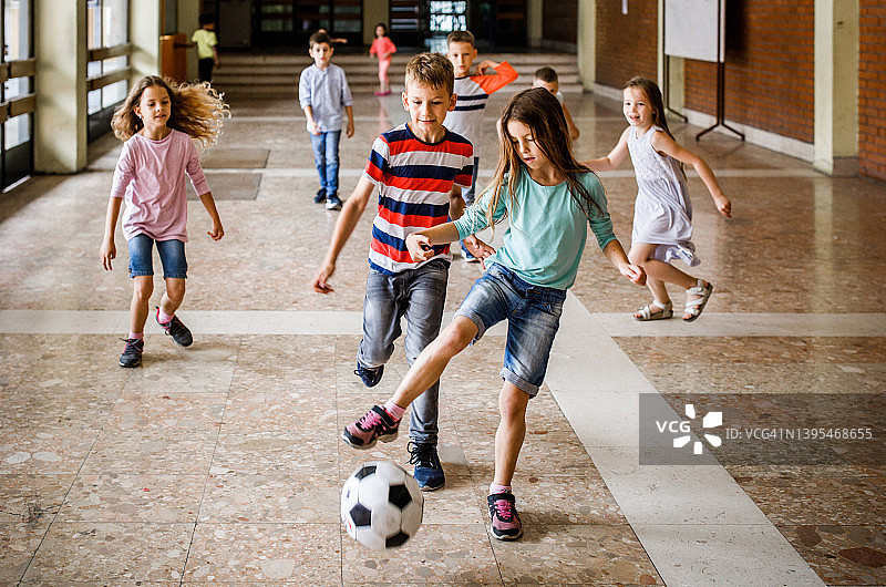 在走廊里玩球的快乐学生图片素材
