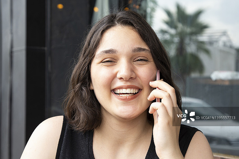 年轻女子在咖啡馆用手机交谈图片素材