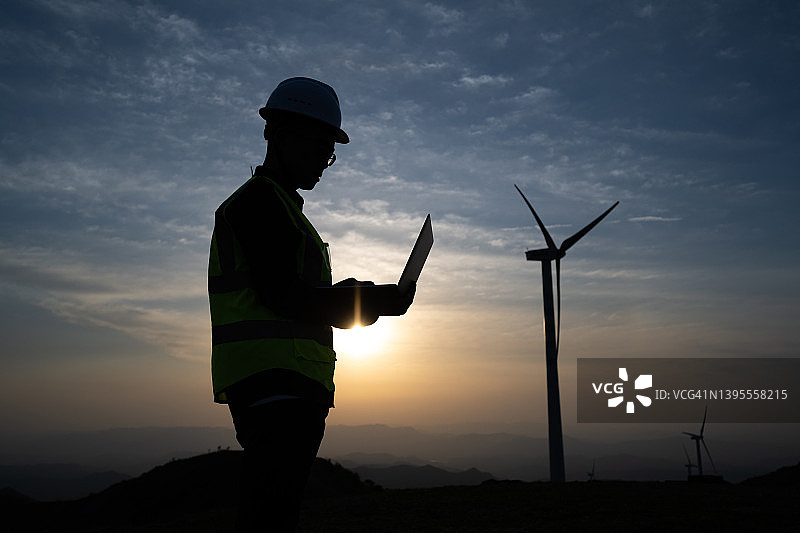 男性电力工程师风力发电场剪影图片素材