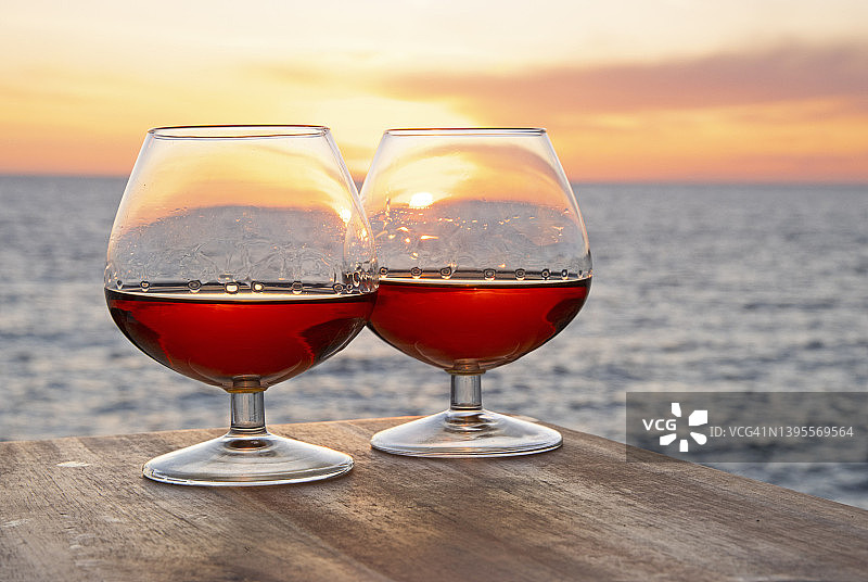 沿海日落前景中的一对白兰地酒杯图片素材