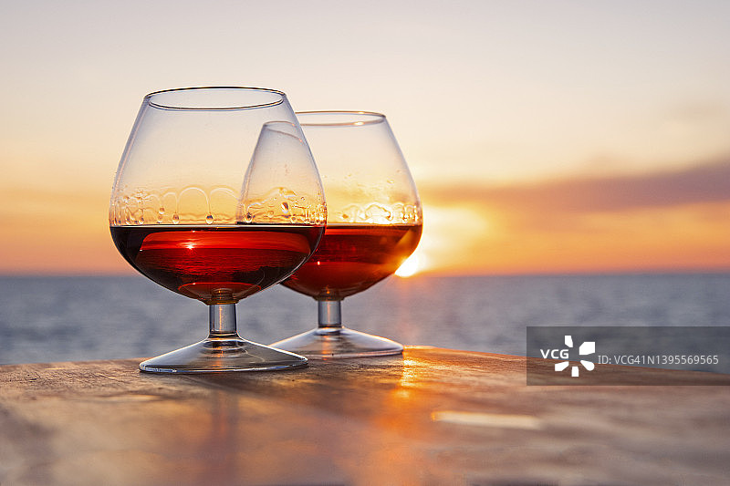 沿海日落前景中的一对白兰地酒杯图片素材