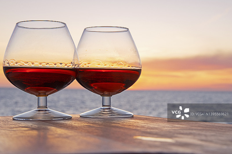 沿海日落前景中的一对白兰地酒杯图片素材