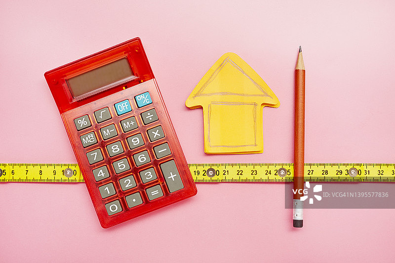 计算器、橙色笔记本上的房屋图纸和铅笔（高角度）图片素材