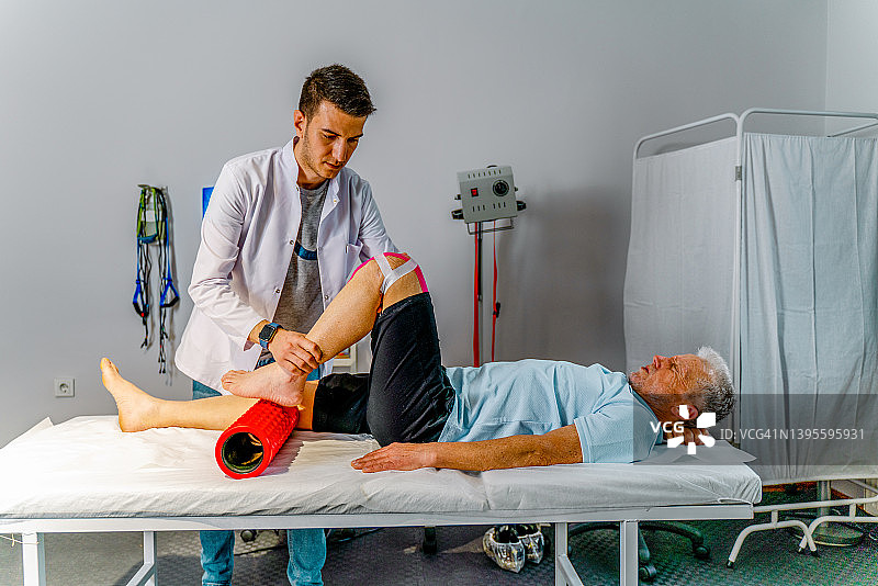 理疗师为老年患者进行腿部康复图片素材