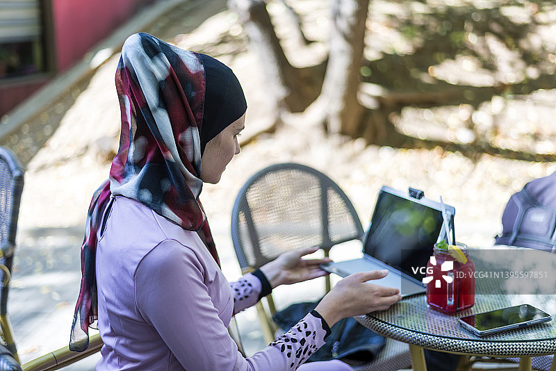 在咖啡馆进行视频通话的穆斯林女性图片素材