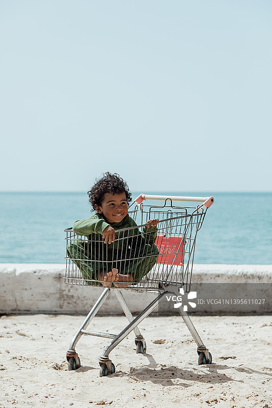 海边沙滩上非洲式发型小男孩图片素材