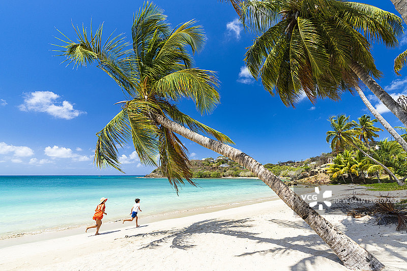 在海滩上和母亲一起玩耍的可爱小男孩图片素材