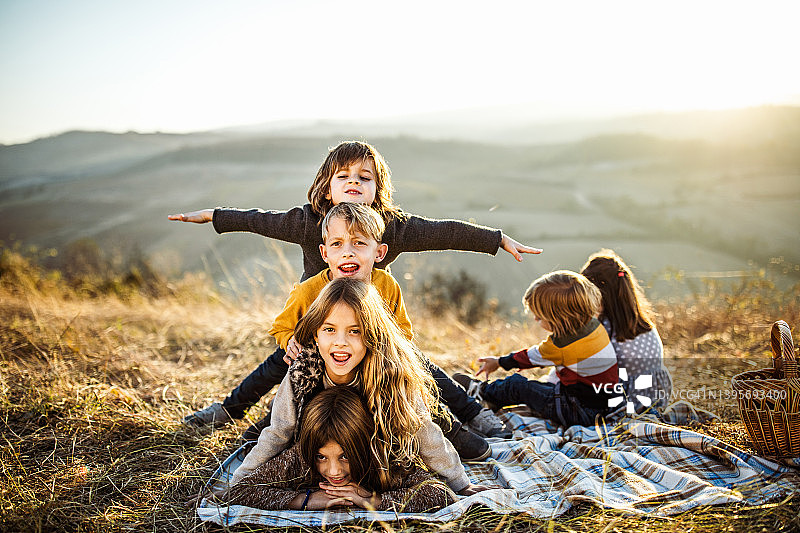 孩子们在秋日野餐时搭人塔图片素材