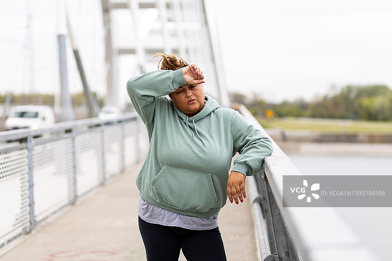 疲惫的超重西班牙裔妇女因锻炼而筋疲力尽图片素材