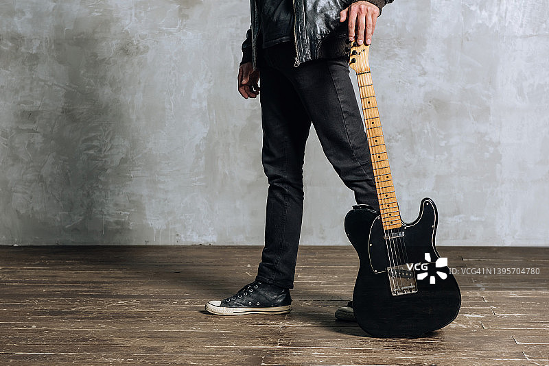 男性吉他手的腿部特写，与吉他图片素材