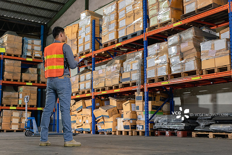 仓库工人检查产品，仓库和配送概念图片素材
