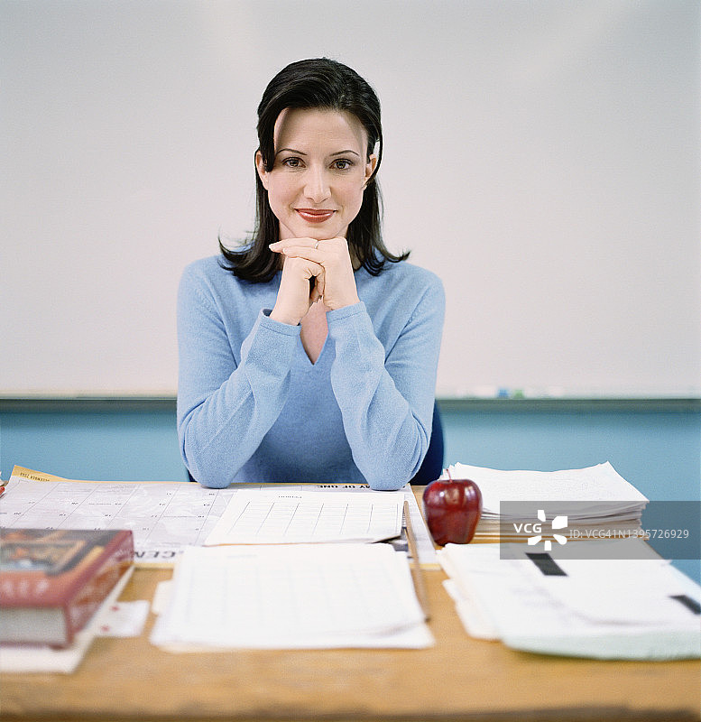 老师坐在书桌后肖像图片素材