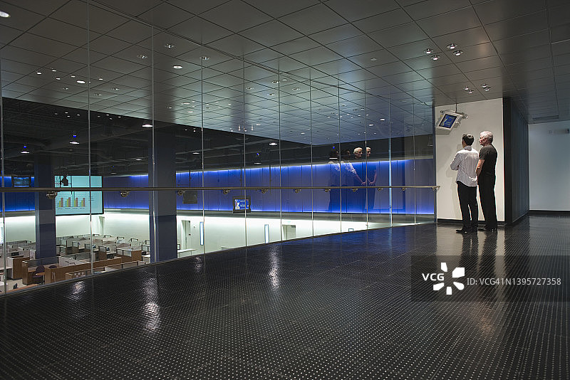 商人在现代办公室观看数据屏幕图片素材