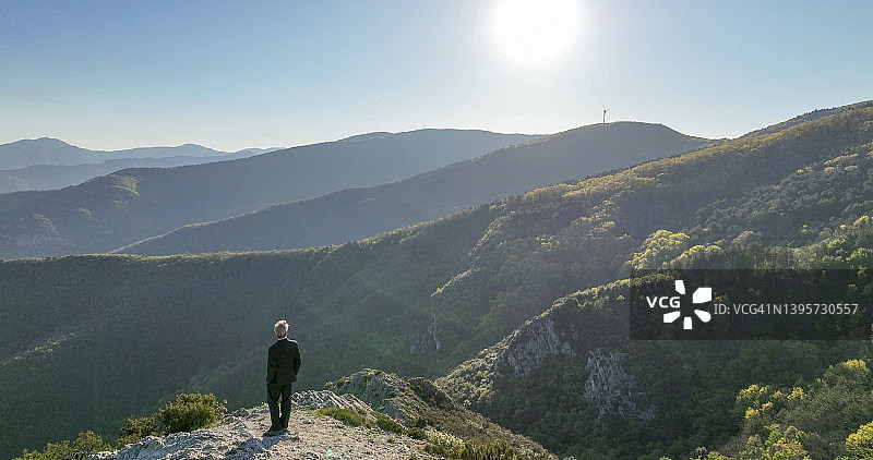 站在山顶的商务男士鸟瞰图图片素材