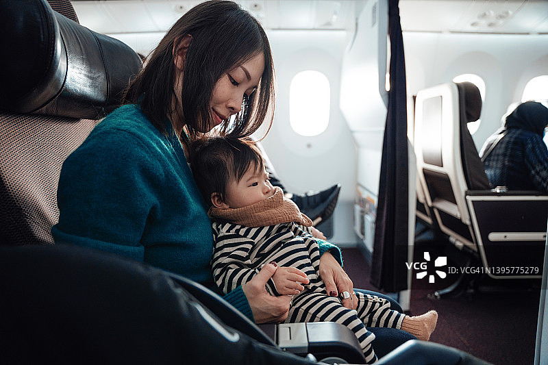 亚洲母亲和她的宝宝一起玩飞行游戏图片素材