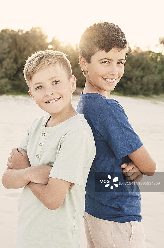 两个男孩背靠背站立图片素材