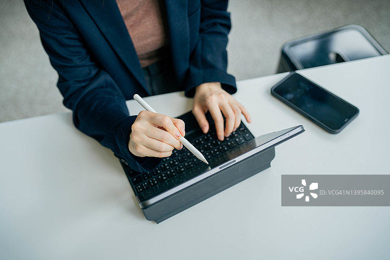 在咖啡馆使用笔记本电脑工作的亚洲女性图片素材