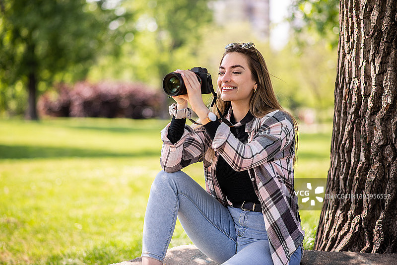自由职业女性摄影师手持相机，创意职业概念图片素材