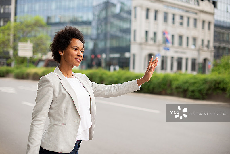 在街上等出租车的非裔美国女人图片素材