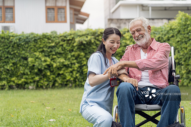 坐在轮椅上的年长男人被护士照顾图片素材