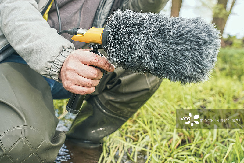 该男子手持麦克风枪录制自然之声图片素材