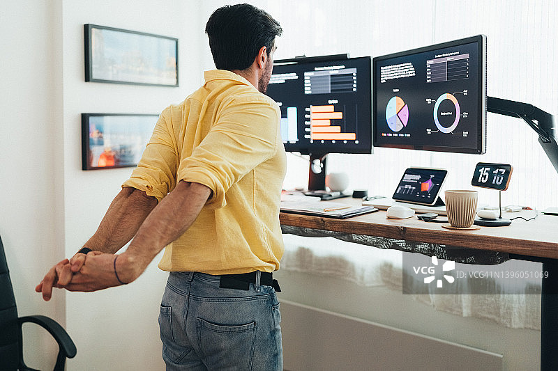 在站立式办公桌前工作的男人图片素材