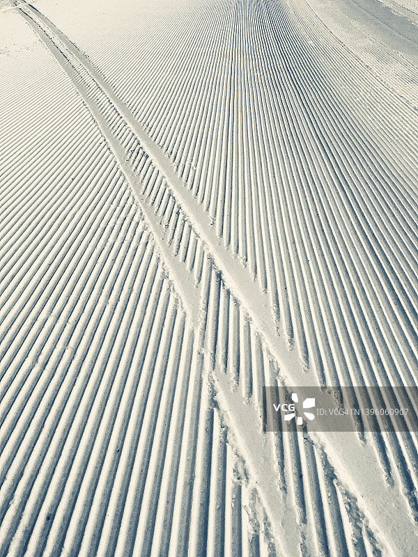 新雪地上的压雪车履带图片素材