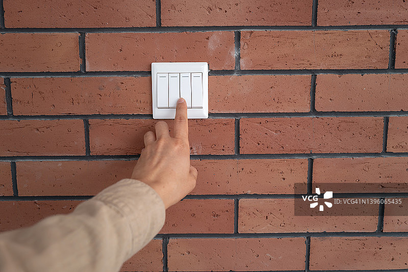 按下红砖墙上的电源开关图片素材