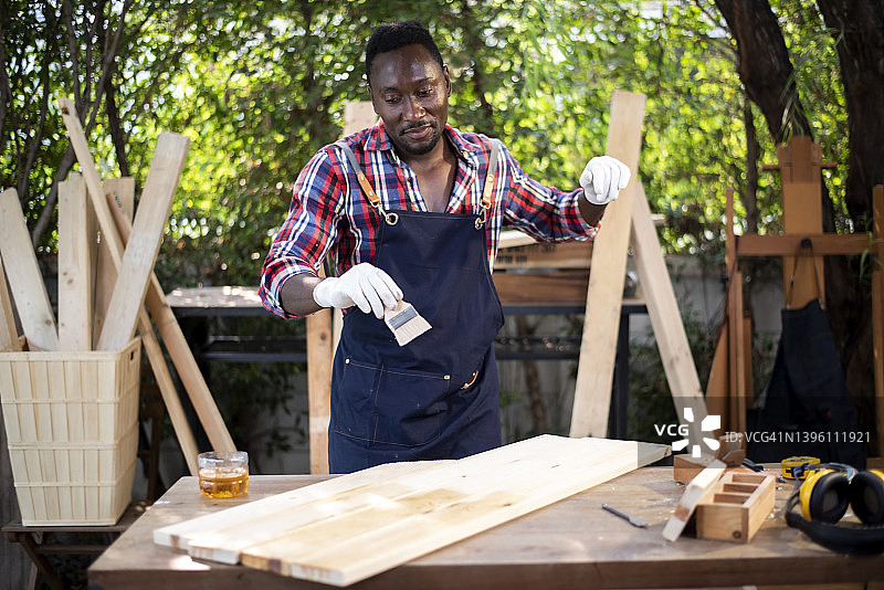 木匠高兴地粉刷木地板图片素材