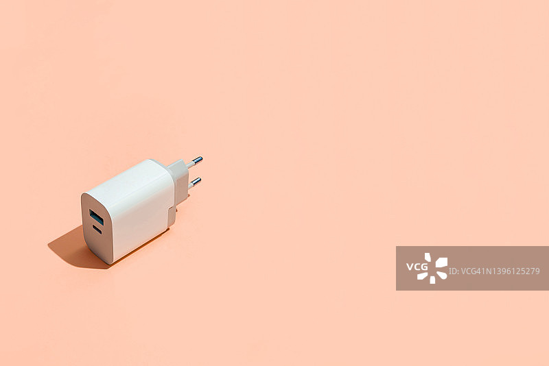 橙色背景上的智能手机USB充电器图片素材