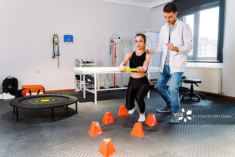 教练在康复中心帮助女人进行腿部和手臂锻炼图片素材