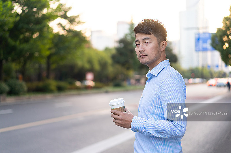 在公交车站等出租车的年轻中国男子图片素材