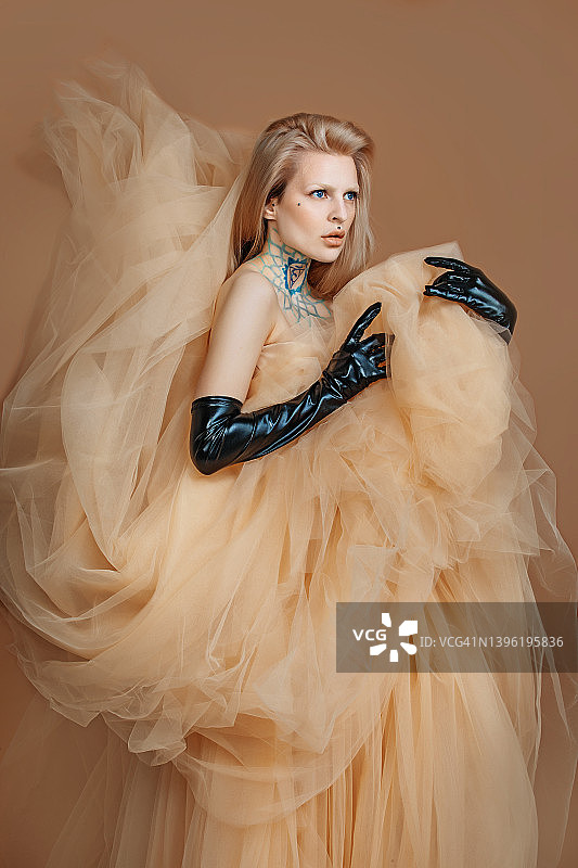 一位穿着奶油色连衣裙的漂亮金发女人图片素材