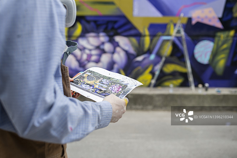 街头艺术家正在看设计图图片素材