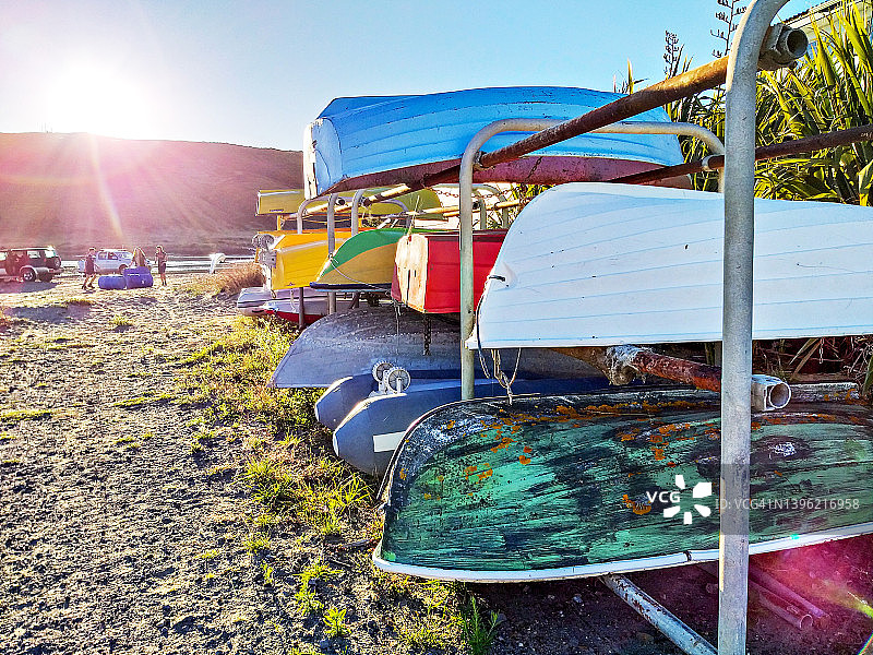波里鲁阿的彩色独木舟和皮划艇架子，沐浴在午后金色的阳光下，新西兰图片素材