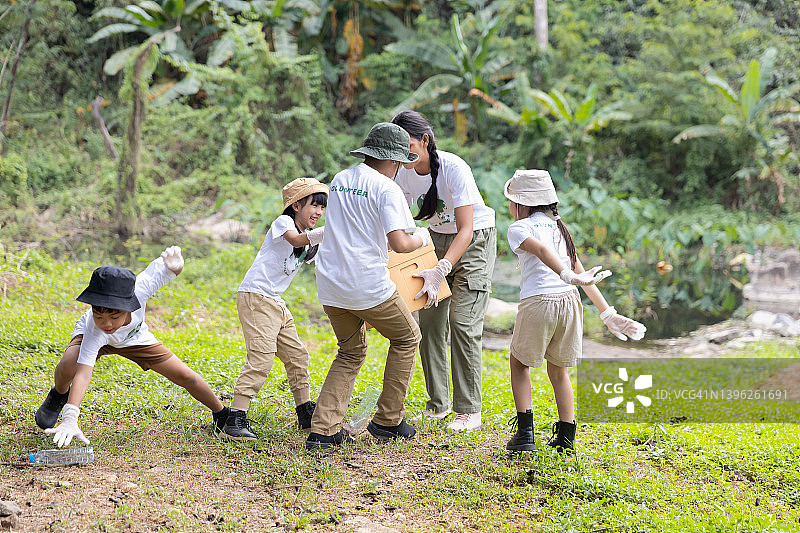 一群孩子自愿一起将塑料瓶放入回收箱图片素材